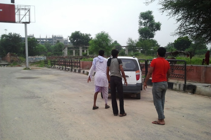 men help push car off the road in Jaiipur, India
